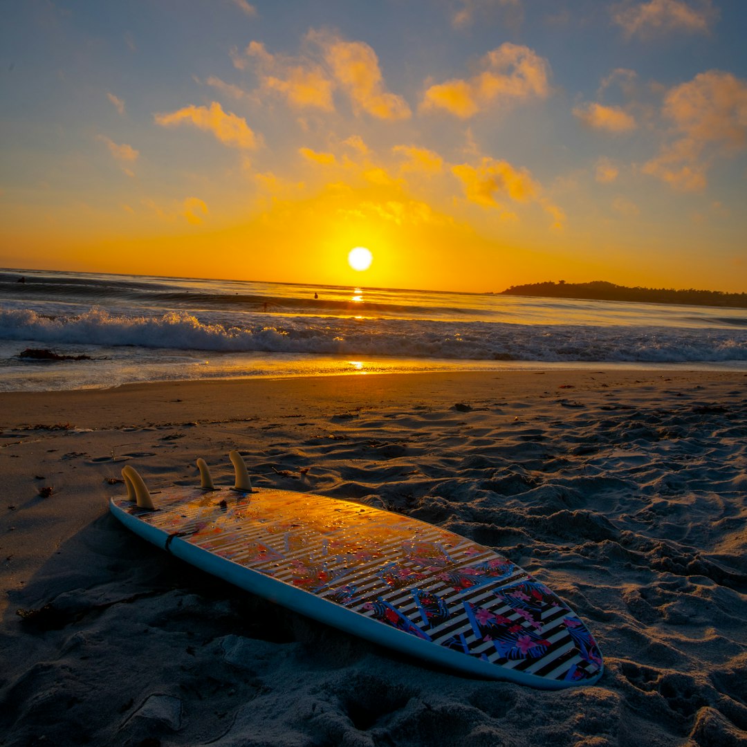 blue and white boat on beach during sunset