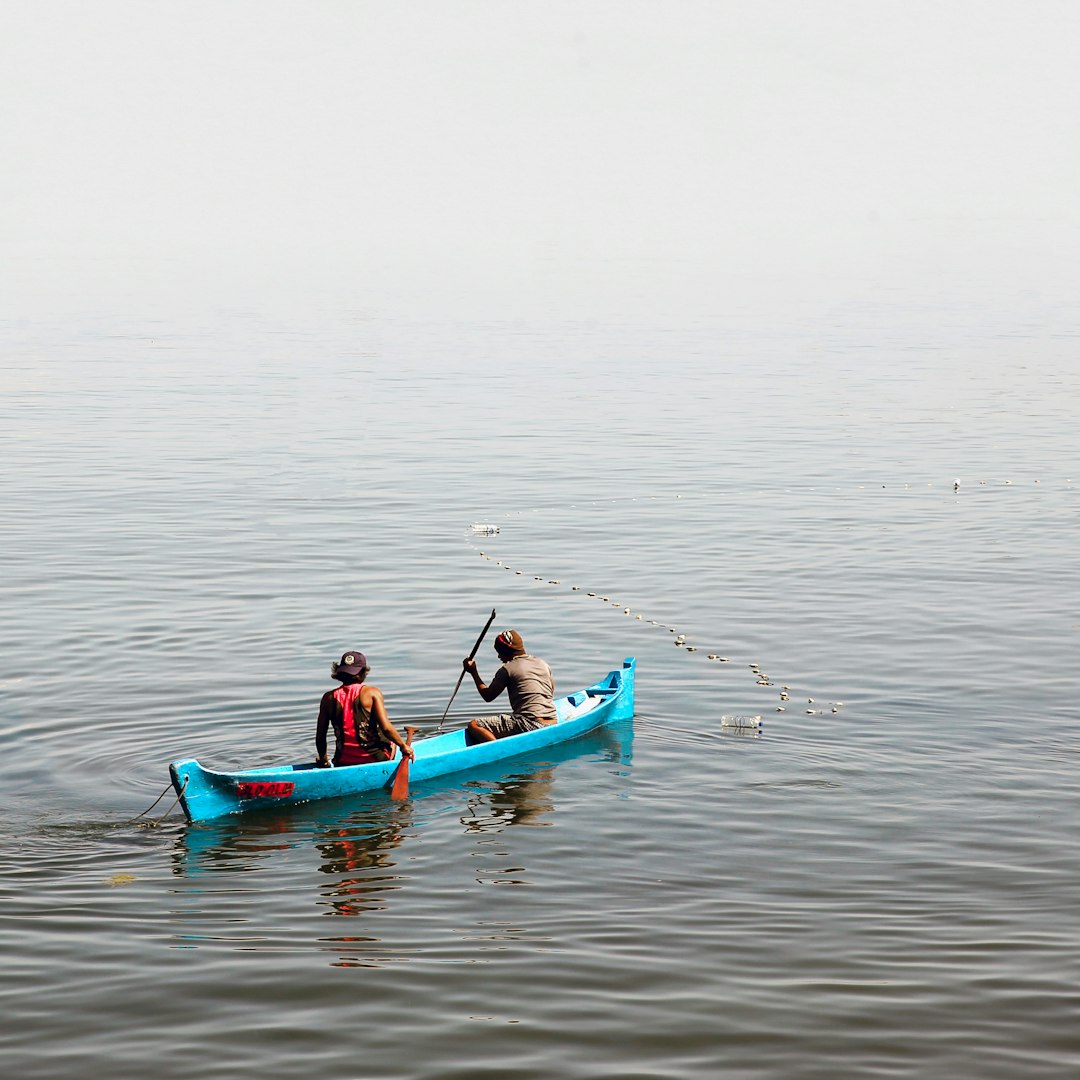 2 person in boat at body of water