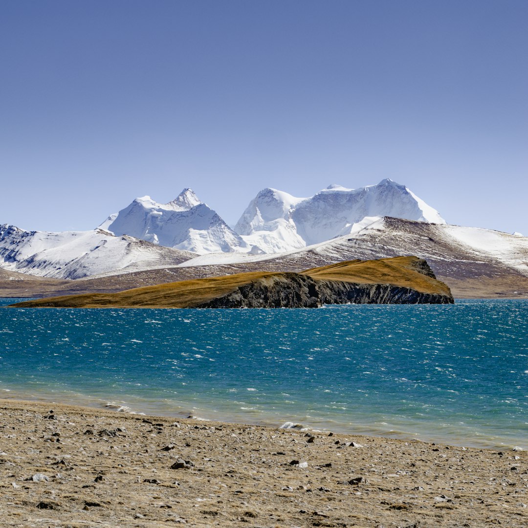 Turquoise lake with snowy mountains and island