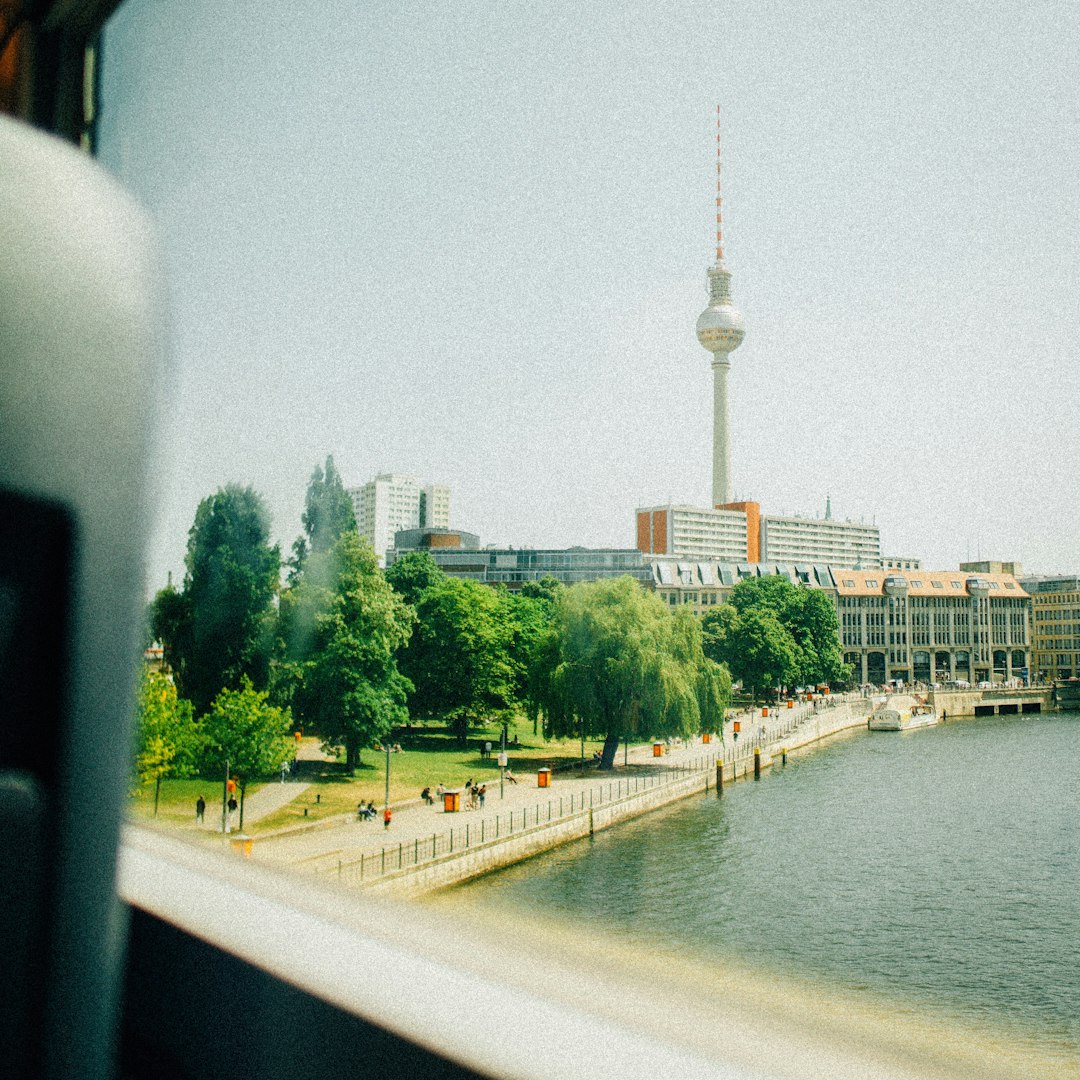 Berlin cityscape with fernsehturm, river, and green trees