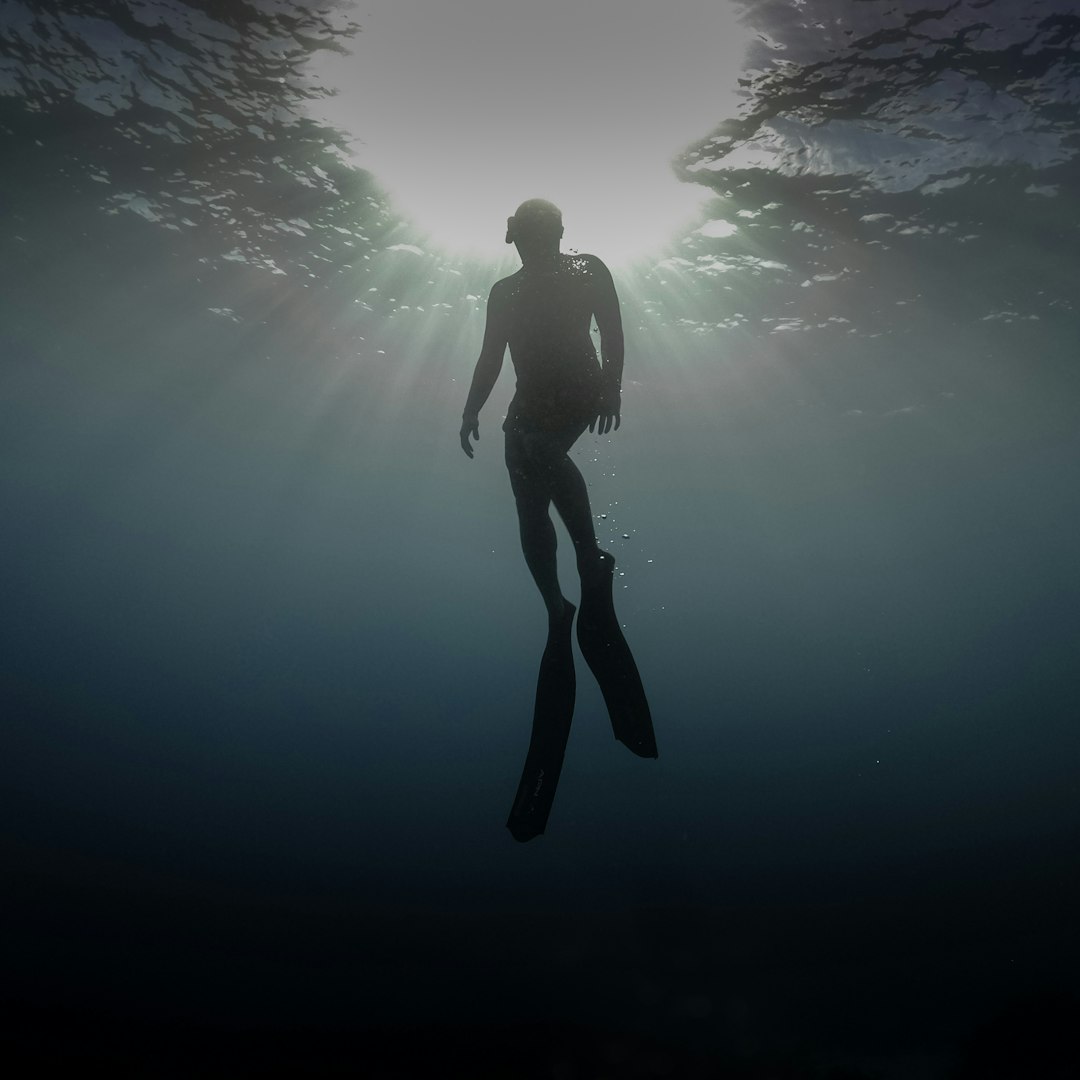 man in black shorts under water