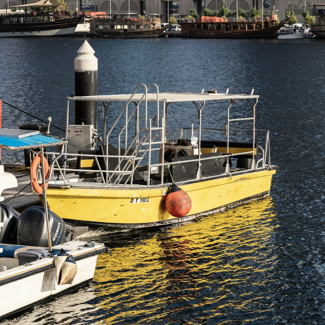 a yellow boat in the water next to a dock