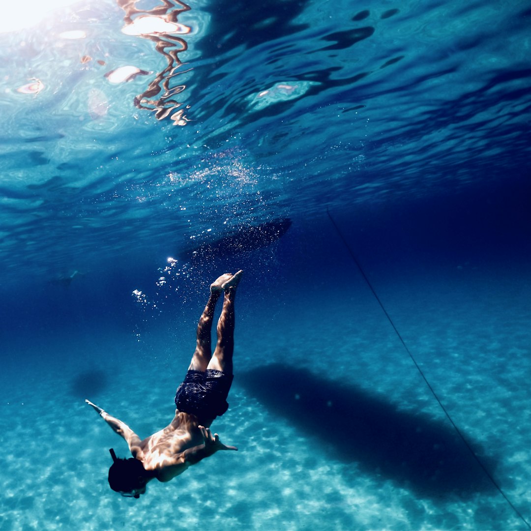 a man is swimming in the water with a rope