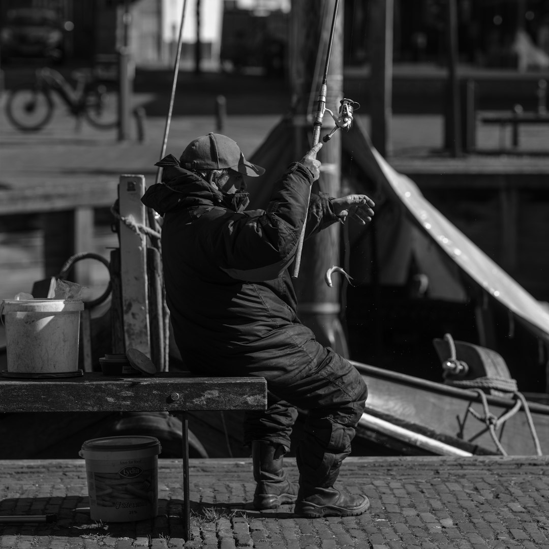 A fisherman is fishing by the water