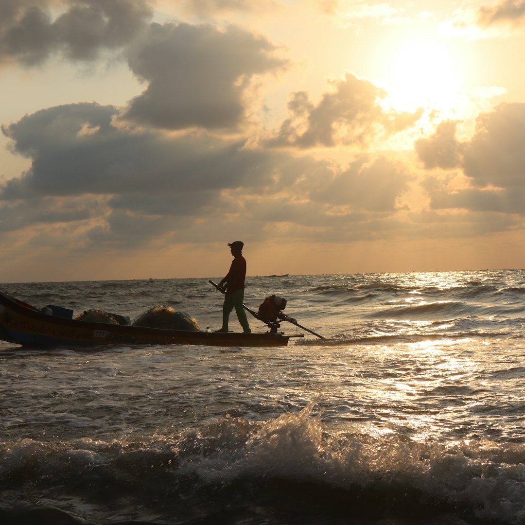 a man standing on top of a boat in the ocean