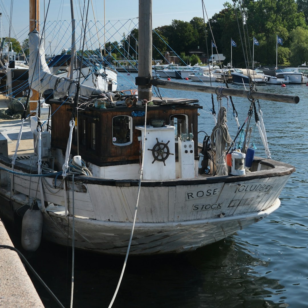A boat docked at a dock with other boats in the water