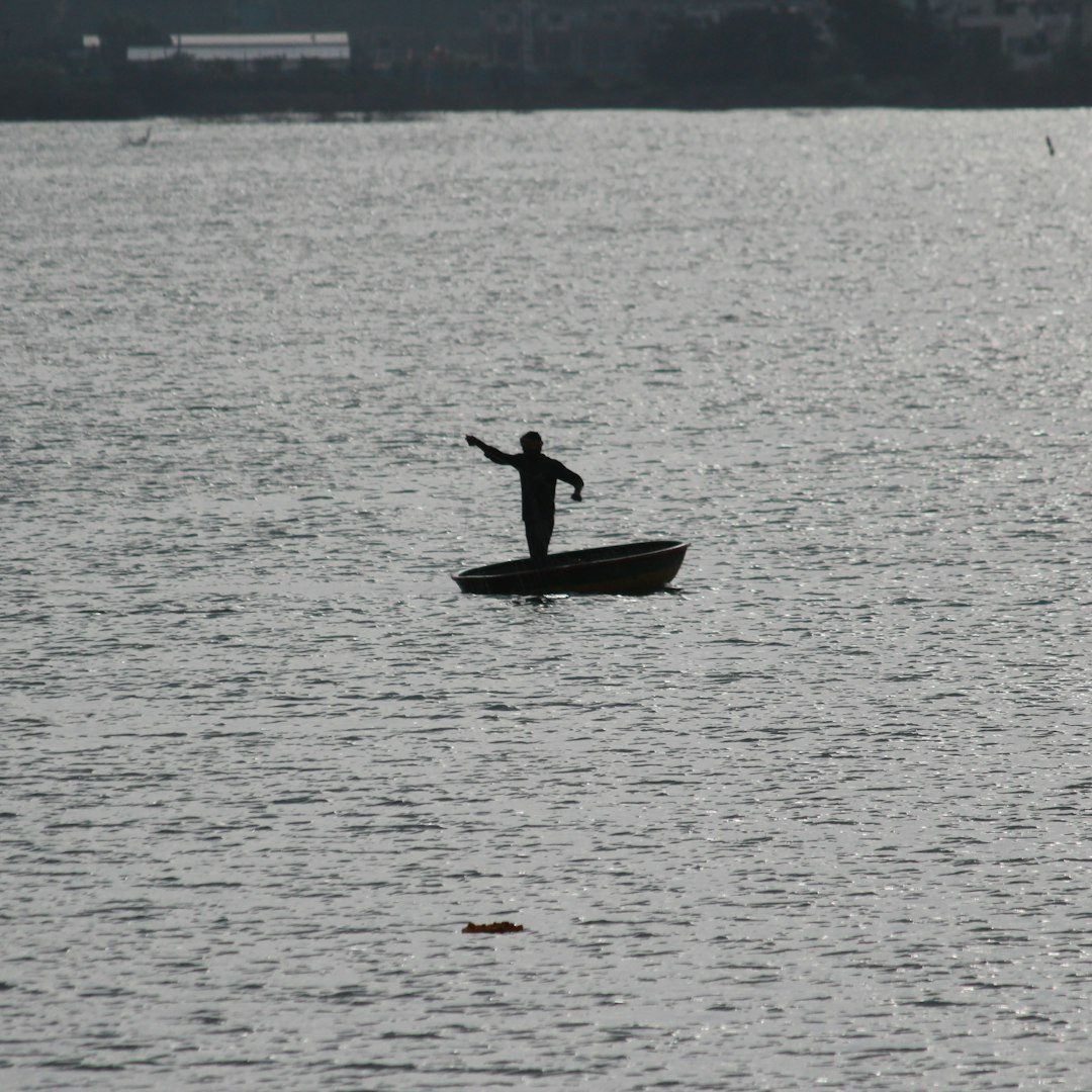 a man standing on a boat in the middle of a lake