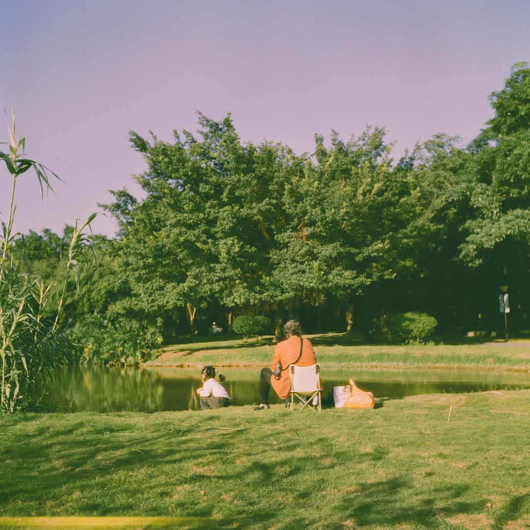 Two people fishing by a calm lake